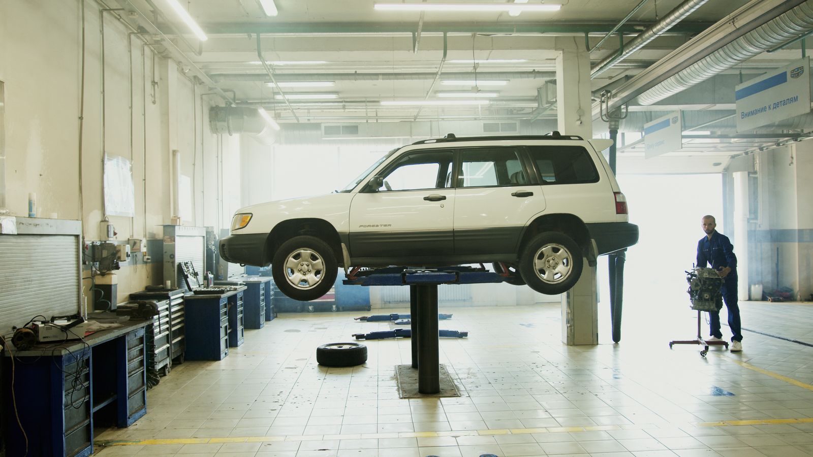Car raised on a lift inside the R & M workshop